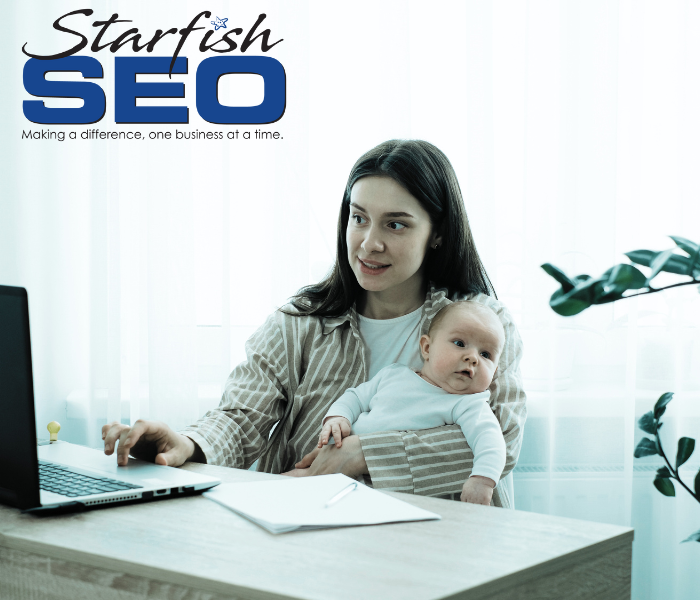 A mother holds a baby while reading content online.